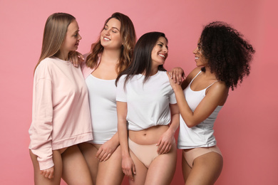 Photo of Group of women with different body types in underwear on pink background
