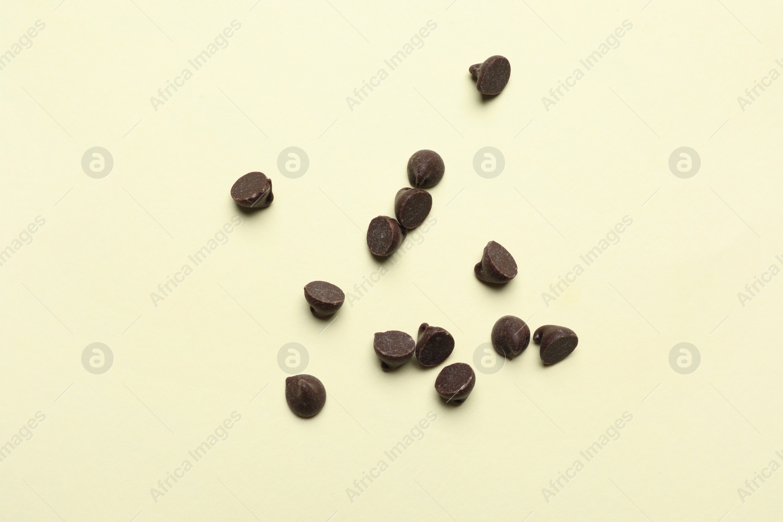 Photo of Delicious chocolate chips on beige background, top view