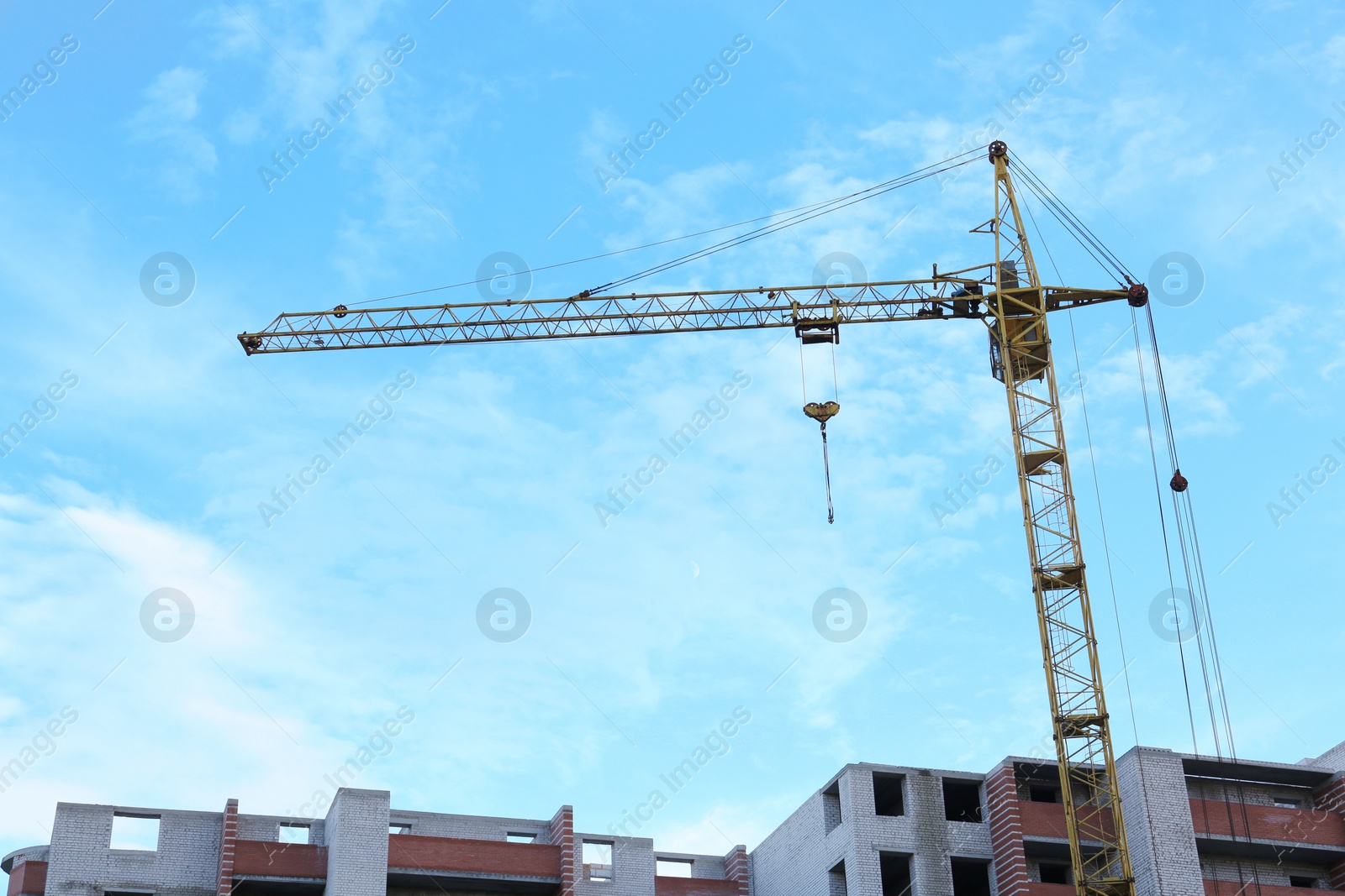 Photo of Construction site with tower crane near unfinished building