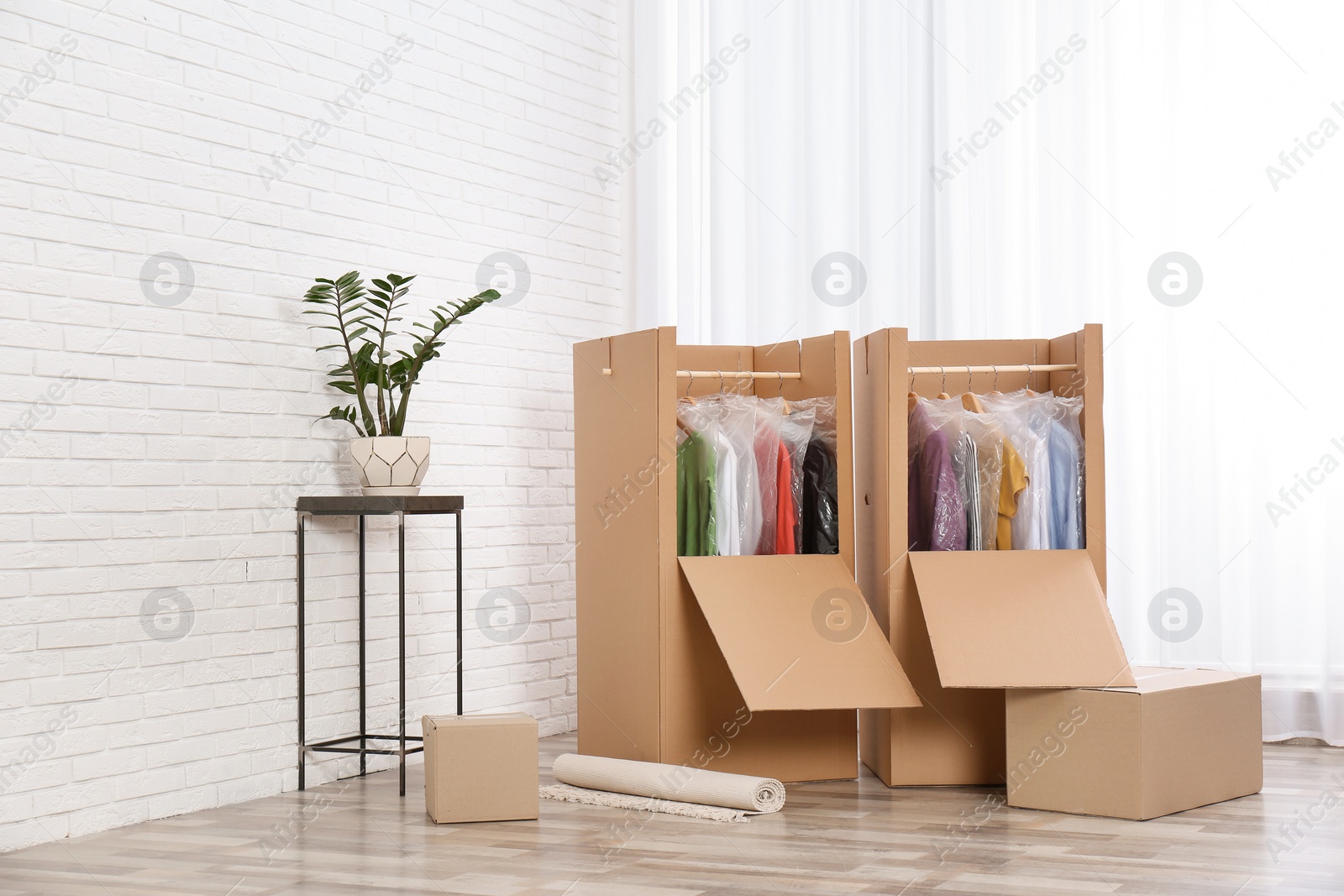 Photo of Wardrobe boxes with clothes near window indoors