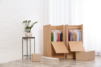 Photo of Wardrobe boxes with clothes near window indoors