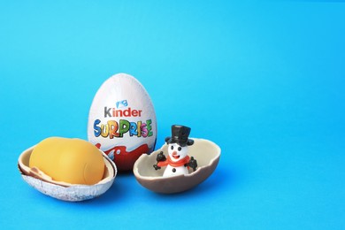 Slynchev Bryag, Bulgaria - May 25, 2023: Kinder Surprise Eggs, plastic capsule and toy snowman on light blue background, space for text