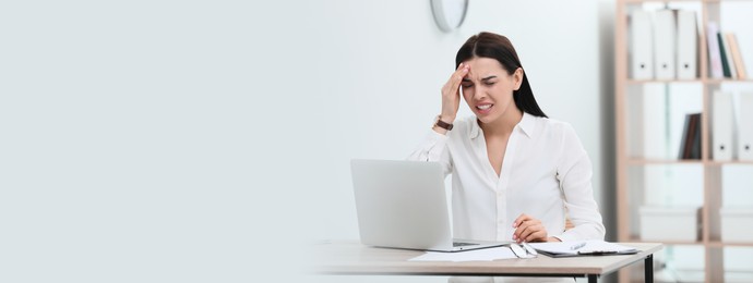 Image of Woman suffering from migraine at workplace in office, space for text. Banner design