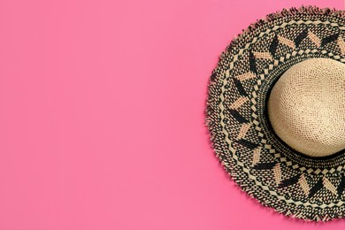 Stylish straw hat on pink background, top view. Space for text