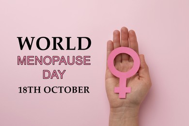 Image of World Menopause Day - October, 18. Woman holding female gender sign on pink background, top view