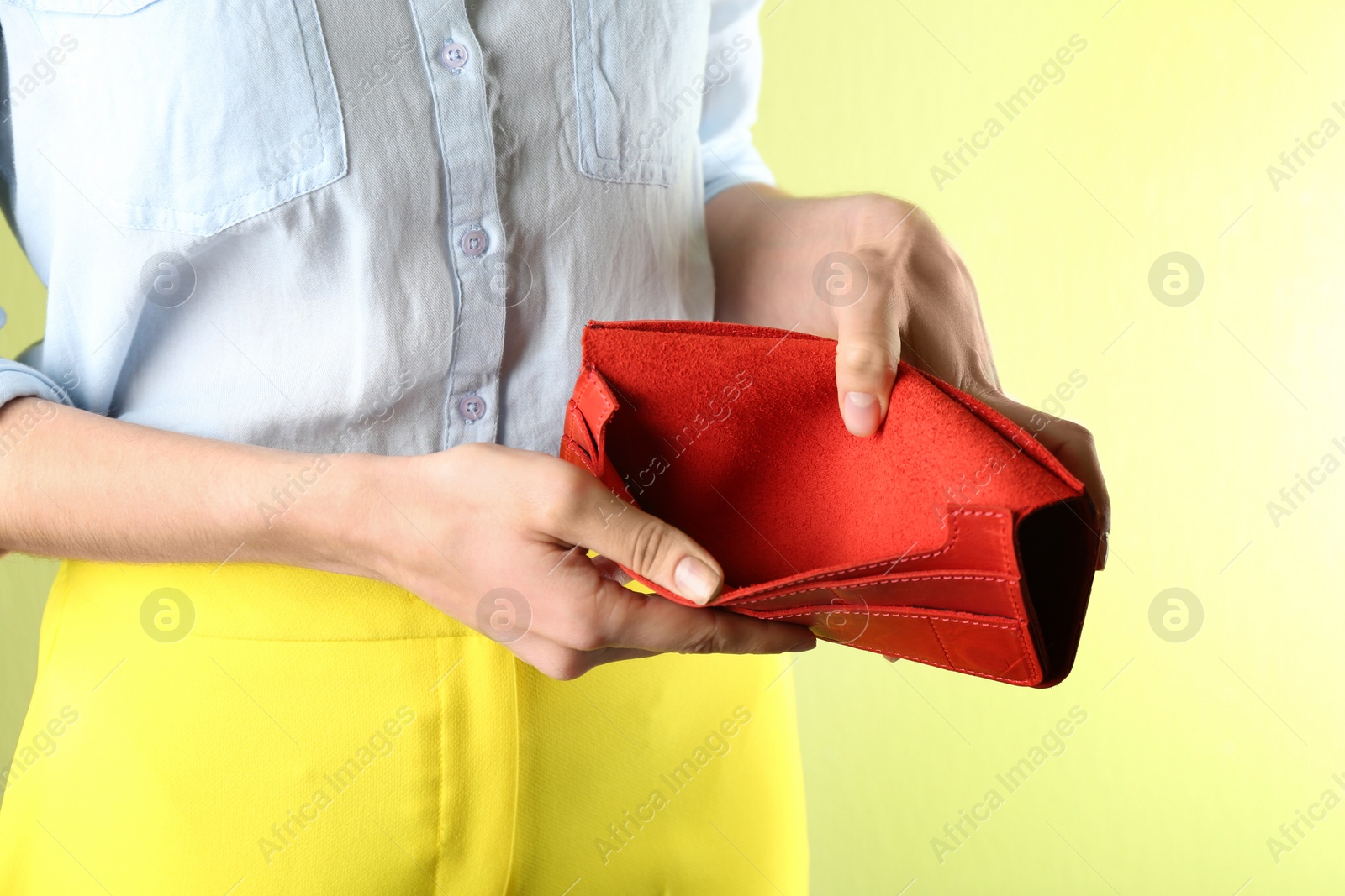 Woman showing empty wallet on light green background, closeup Photo of Woman showing empty wallet on light green background, closeup