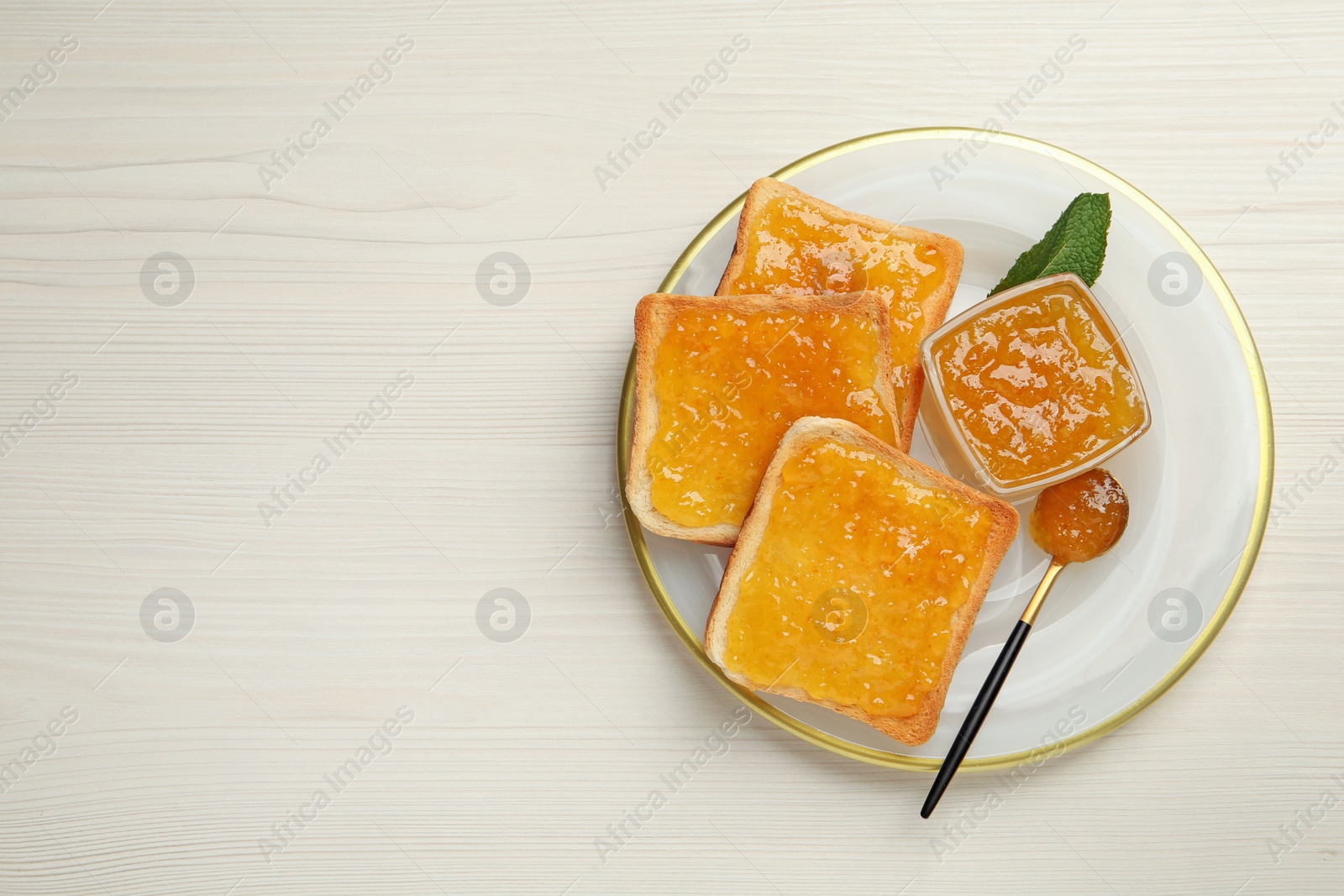 Photo of Delicious toasts with jam served on white wooden table, top view. Space for text