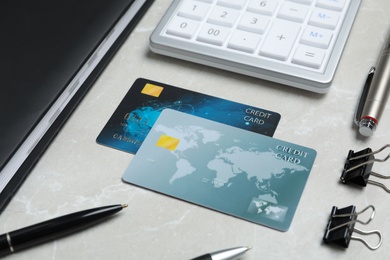 Photo of Credit cards, calculator and stationery on light grey marble table
