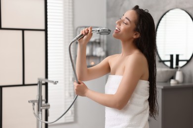 Photo of Happy woman singing after shower in bathroom