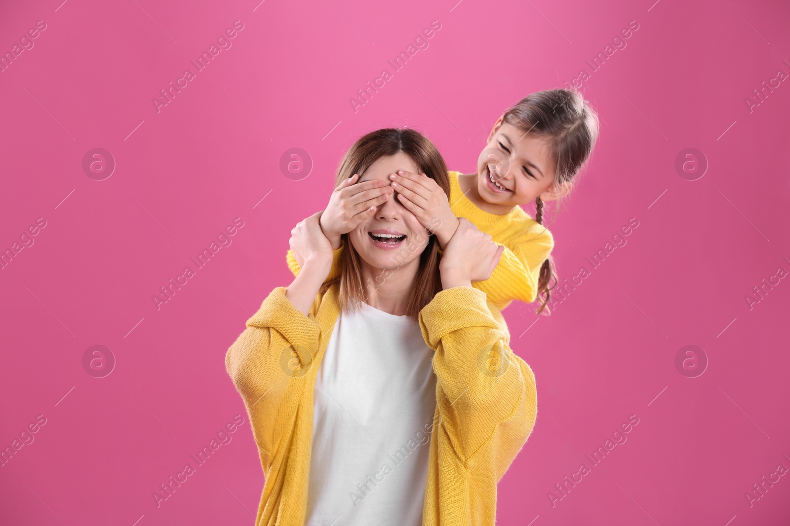 Photo of Happy woman and daughter in stylish clothes on color background