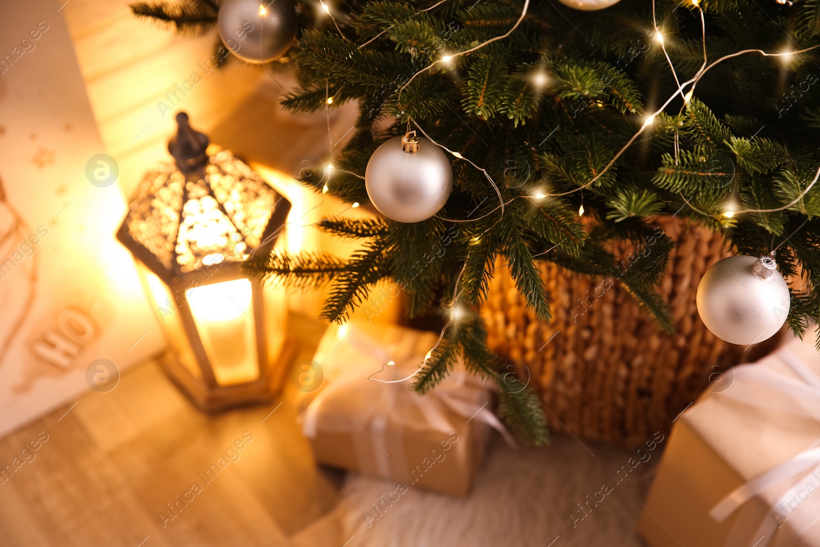 Photo of Beautifully decorated Christmas tree and gift boxes in room. Interior design