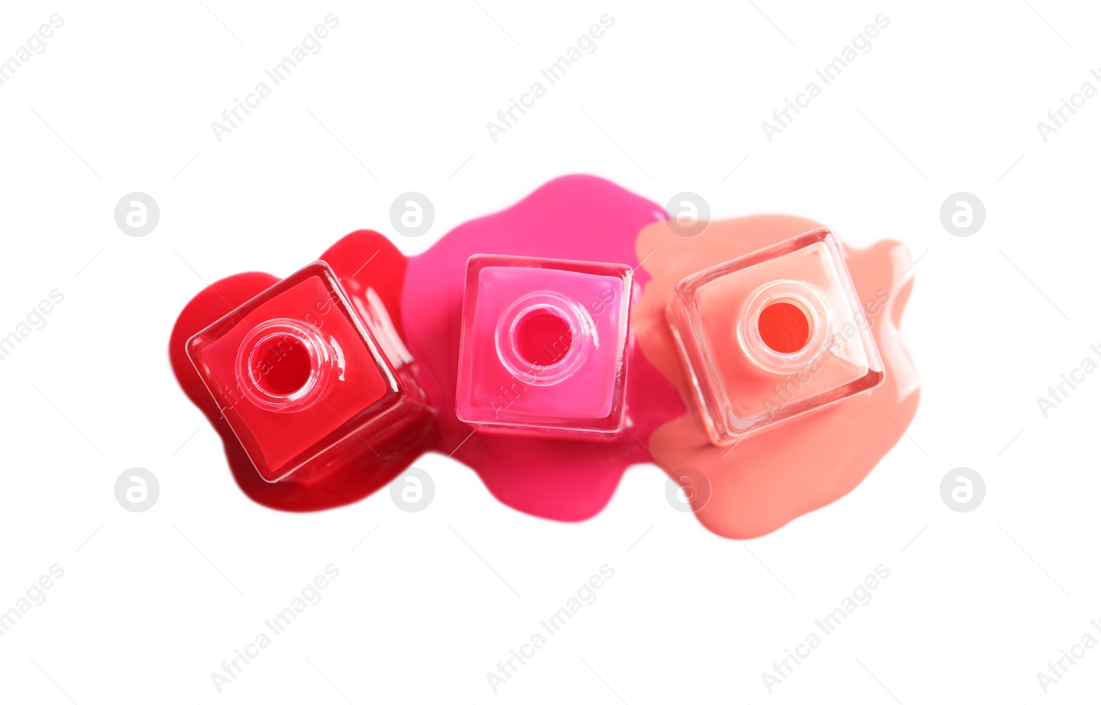 Photo of Spilled different nail polishes with bottles on white background, top view