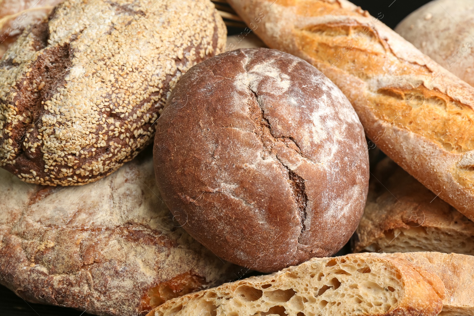 Photo of Different kinds of fresh bread as background, closeup