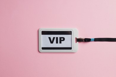 Photo of Plastic vip badge on pale pink background, top view
