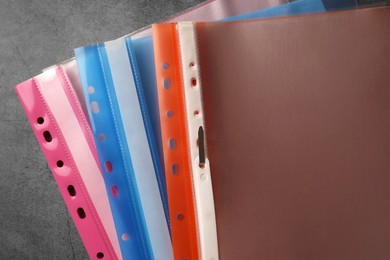File folders with punched pockets on grey table, flat lay
