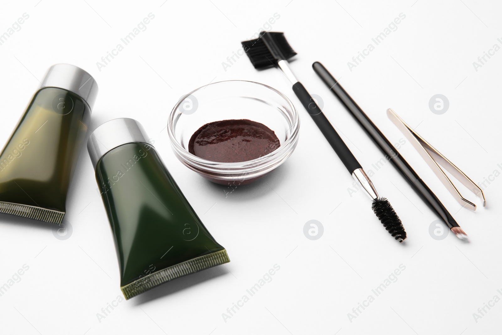 Photo of Eyebrow henna, professional tools and cosmetic products on white background