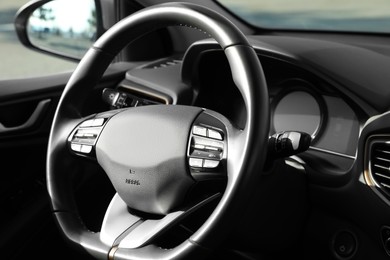 Photo of Black steering wheel inside of modern car, closeup