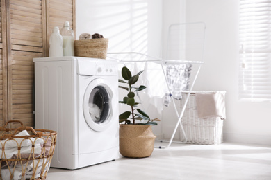 Photo of Modern washing machine in laundry room interior