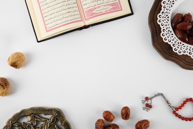 Flat lay composition with Koran, Muslim prayer beads and space for text on white background