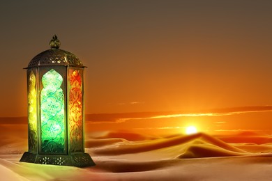 Beautiful Arabic lantern on sand at sunset, space for text