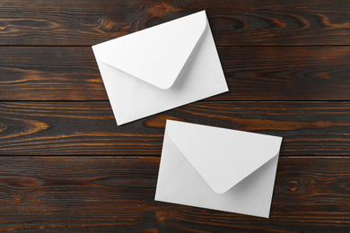 White paper envelopes on wooden background, flat lay