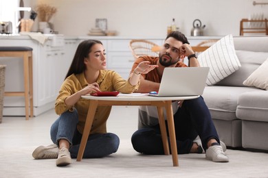 Photo of Young couple discussing family budget at home