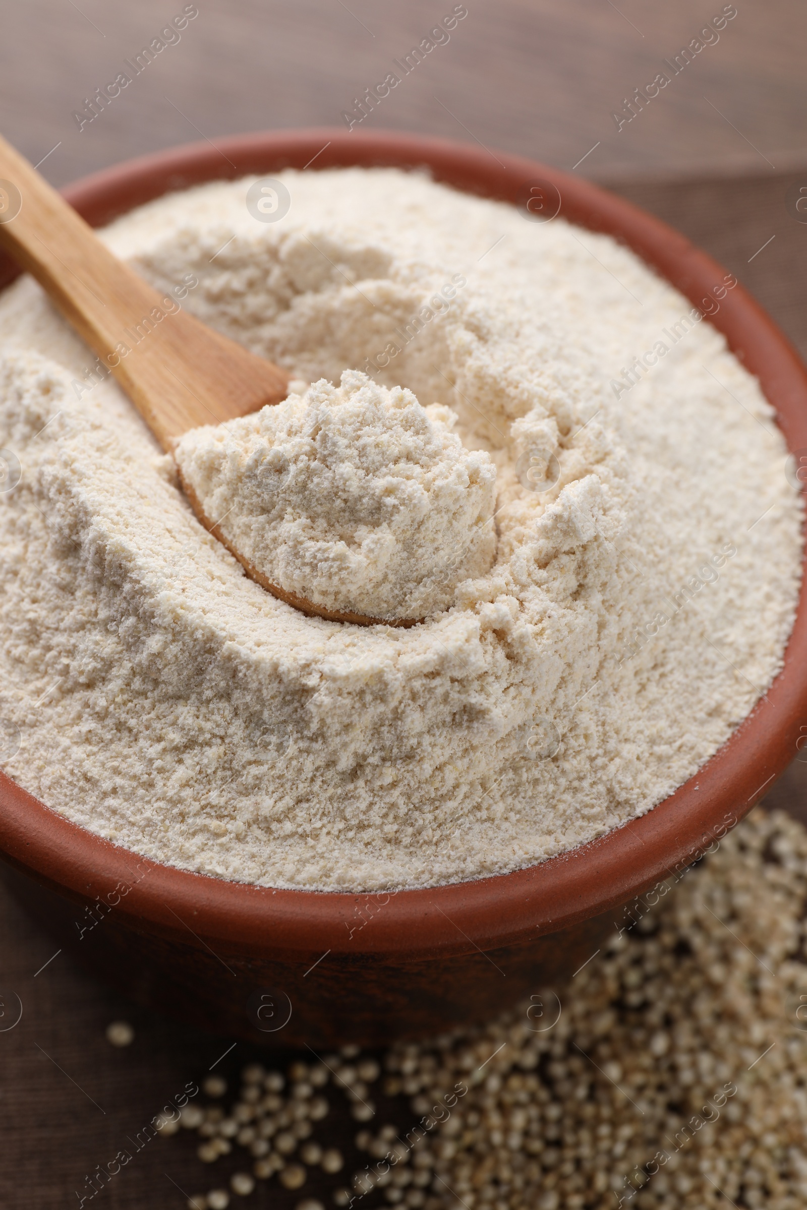 Photo of Quinoa flour in bowl and seeds on wooden table