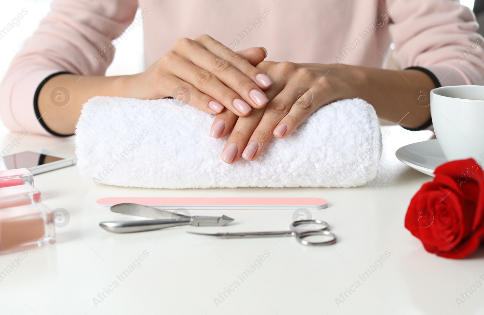 Photo of Woman with perfect manicure at table, closeup. Nail polish trends