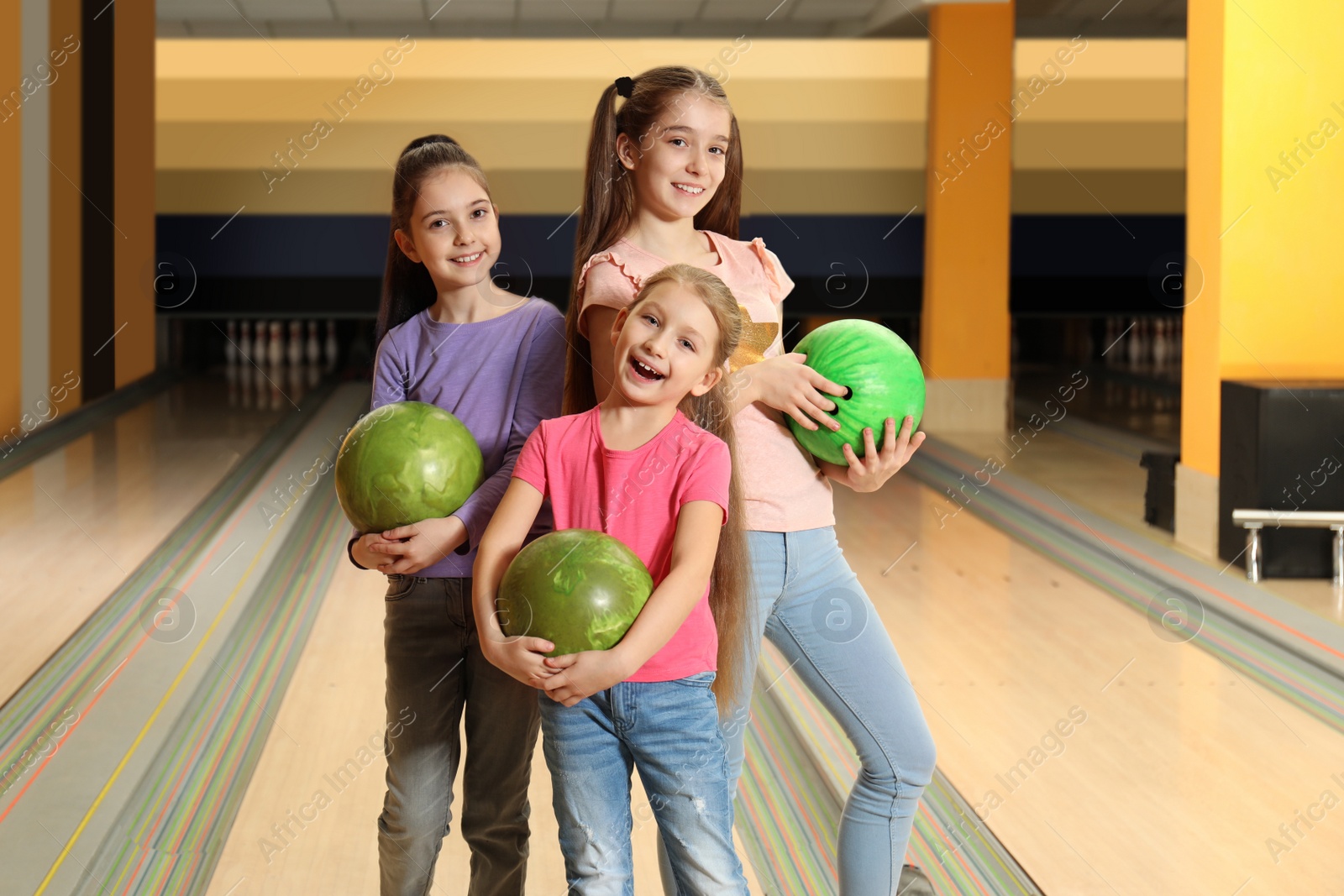 Photo of Happy girls with balls in bowling club