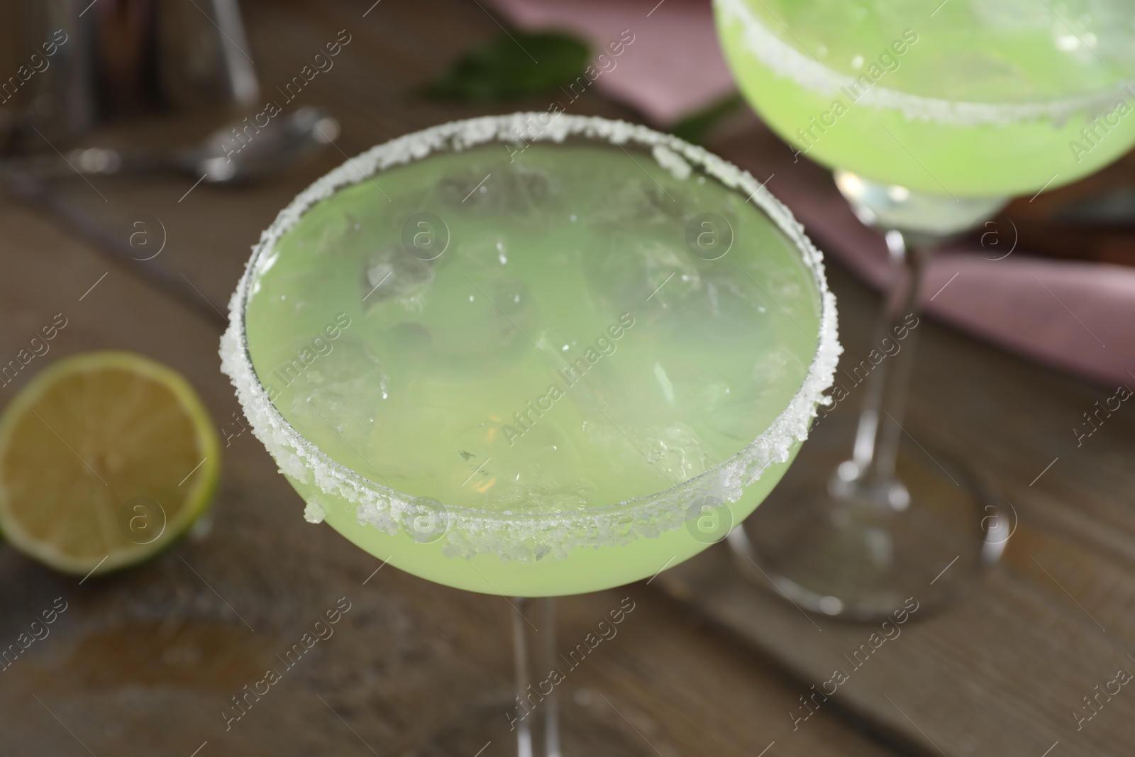 Photo of Delicious Margarita cocktail in glasses on table, closeup