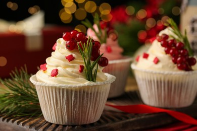 Photo of Delicious cupcakes and Christmas decorations on table, closeup