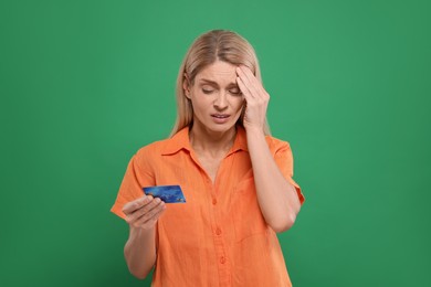 Photo of Stressed woman with credit card on green background. Be careful - fraud