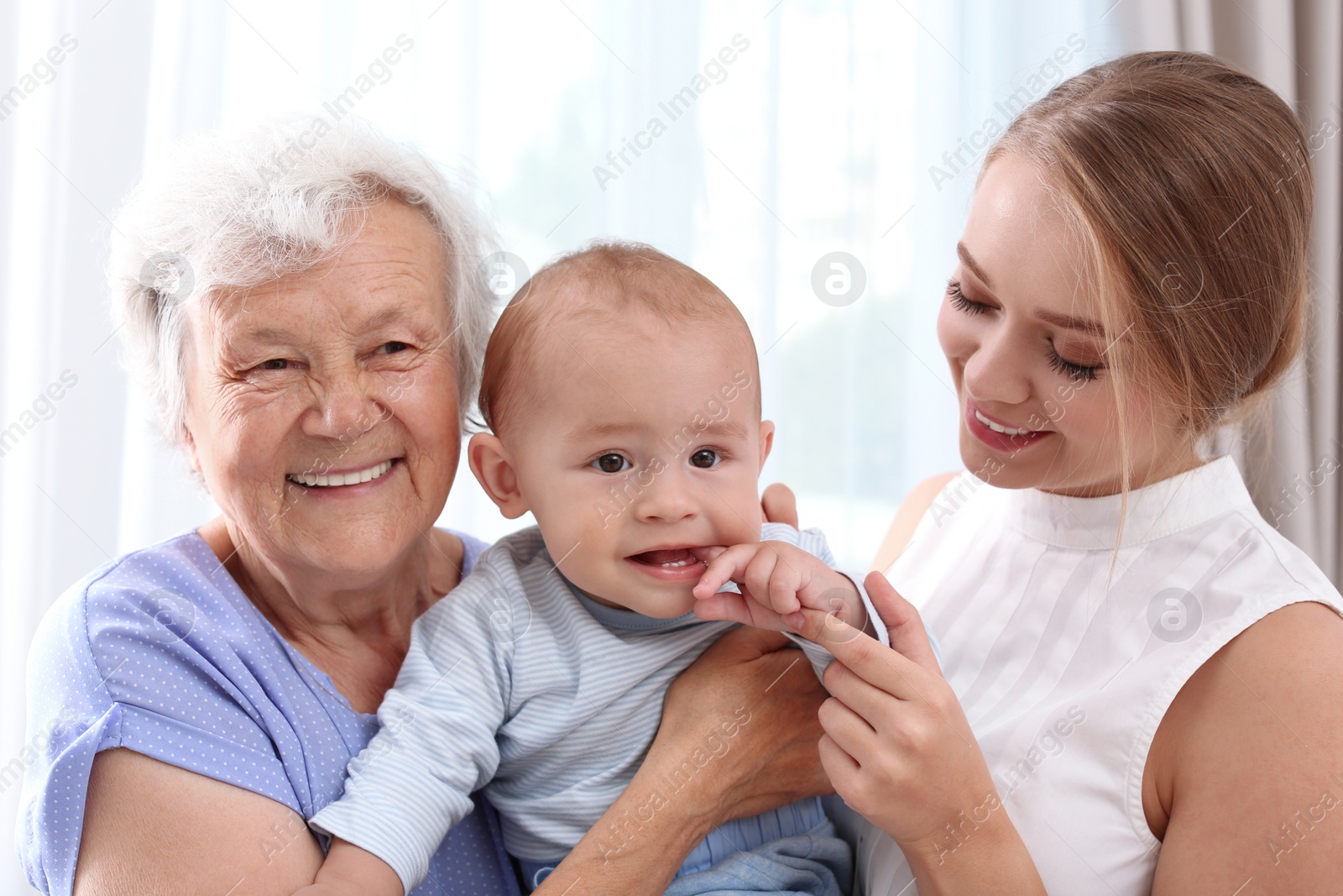 Photo of Happy young woman with her child and grandmother at home