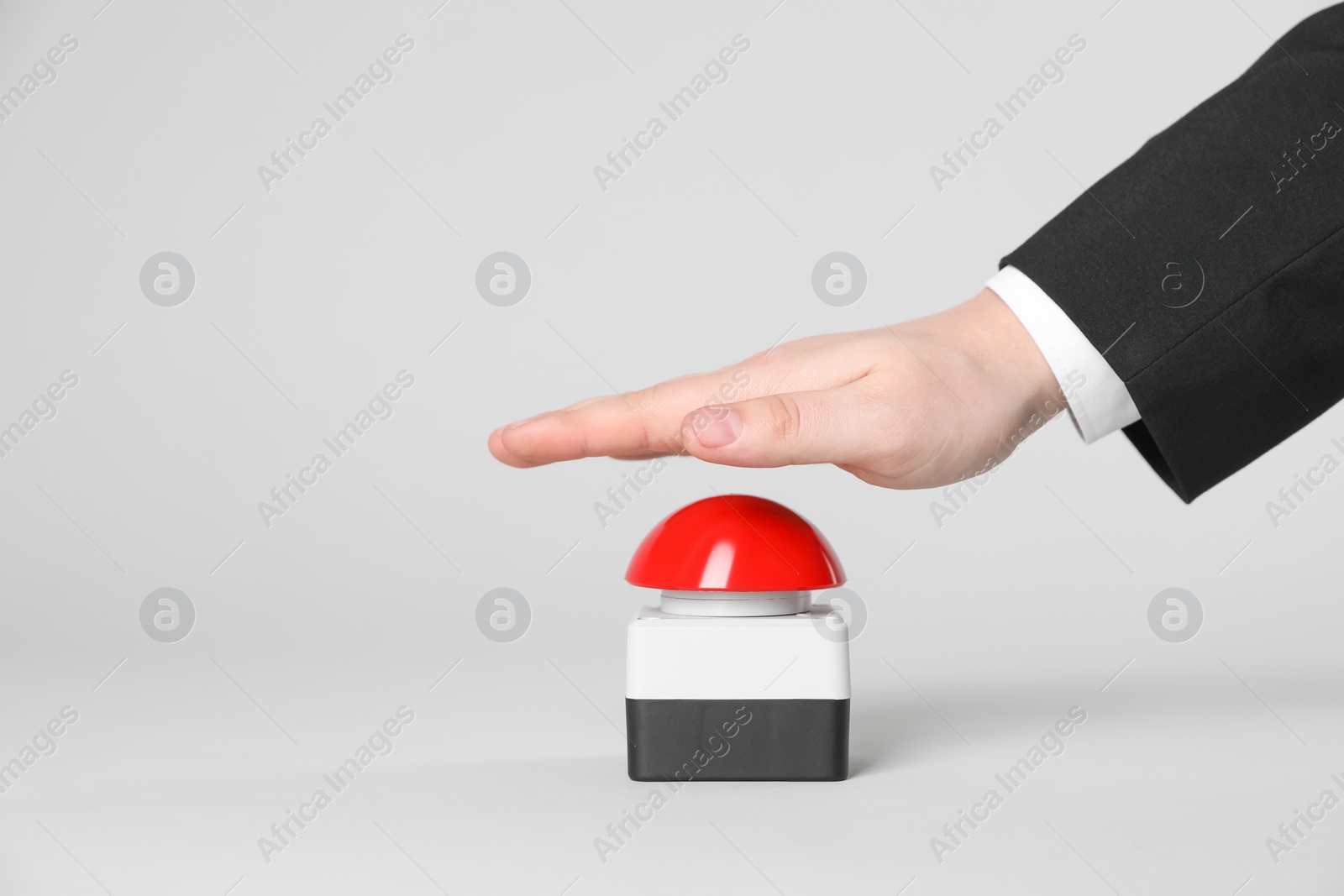 Photo of Man pressing red button of nuclear weapon on light gray background, closeup with space for text. War concept