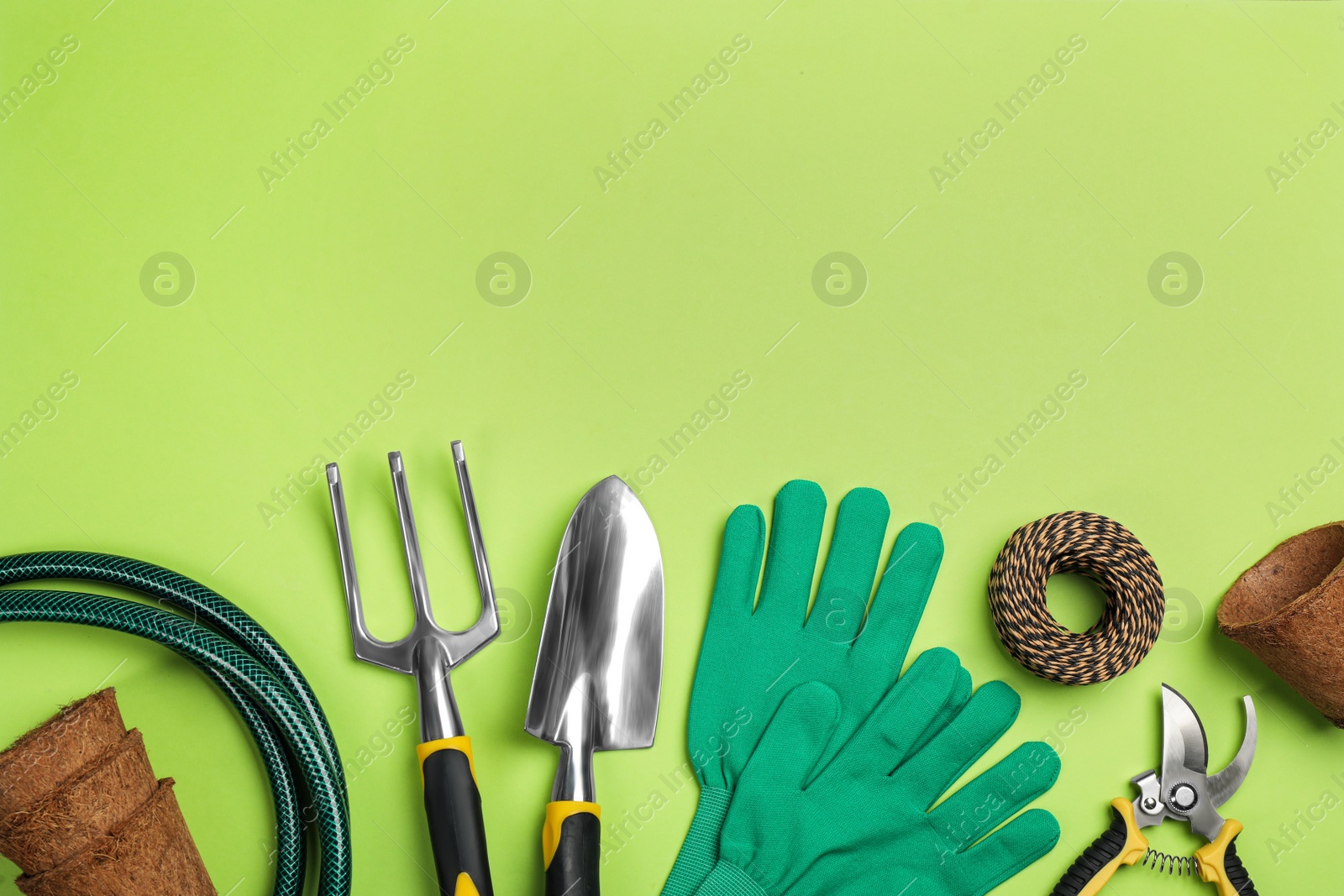 Photo of Flat lay composition with gardening tools on green background, space for text