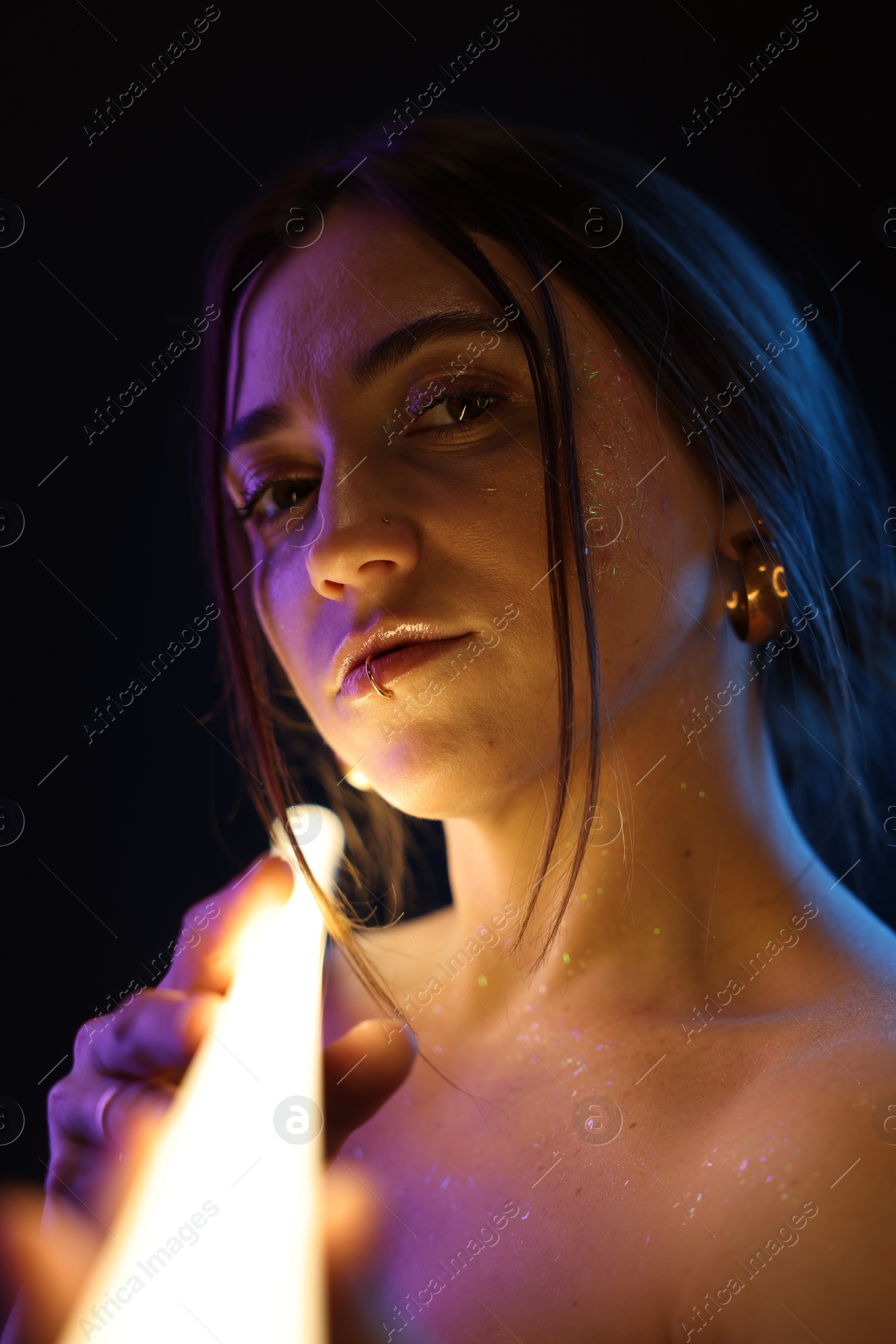 Photo of Beautiful woman with lamp on dark background in neon lights