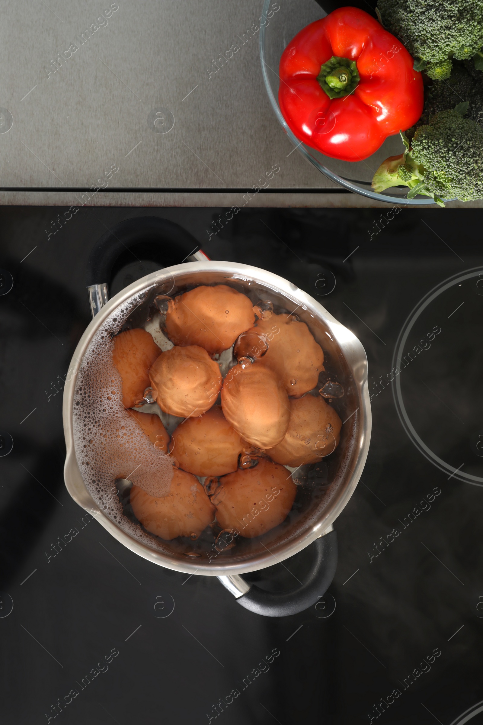 Photo of Cooking chicken eggs in pot on electric stove, top view