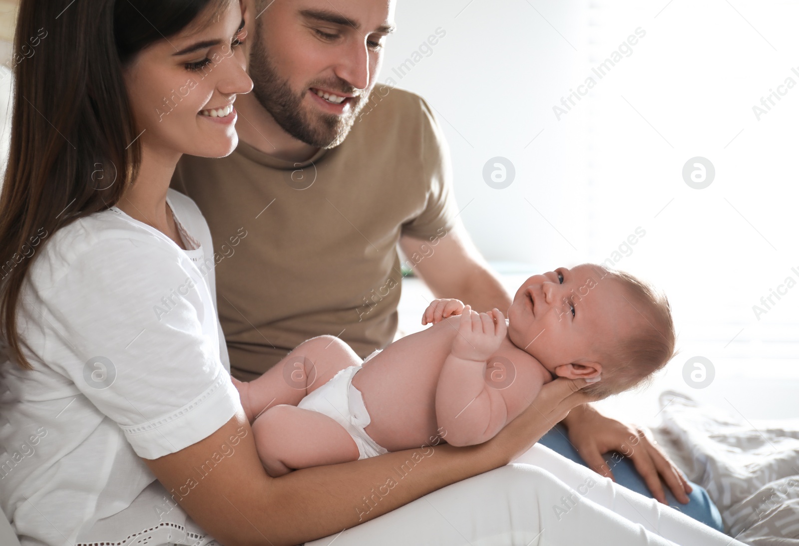 Photo of Happy couple with their newborn baby at home