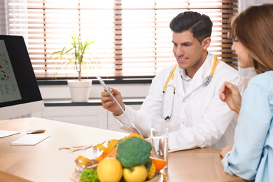 Photo of Nutritionist consulting patient at table in clinic