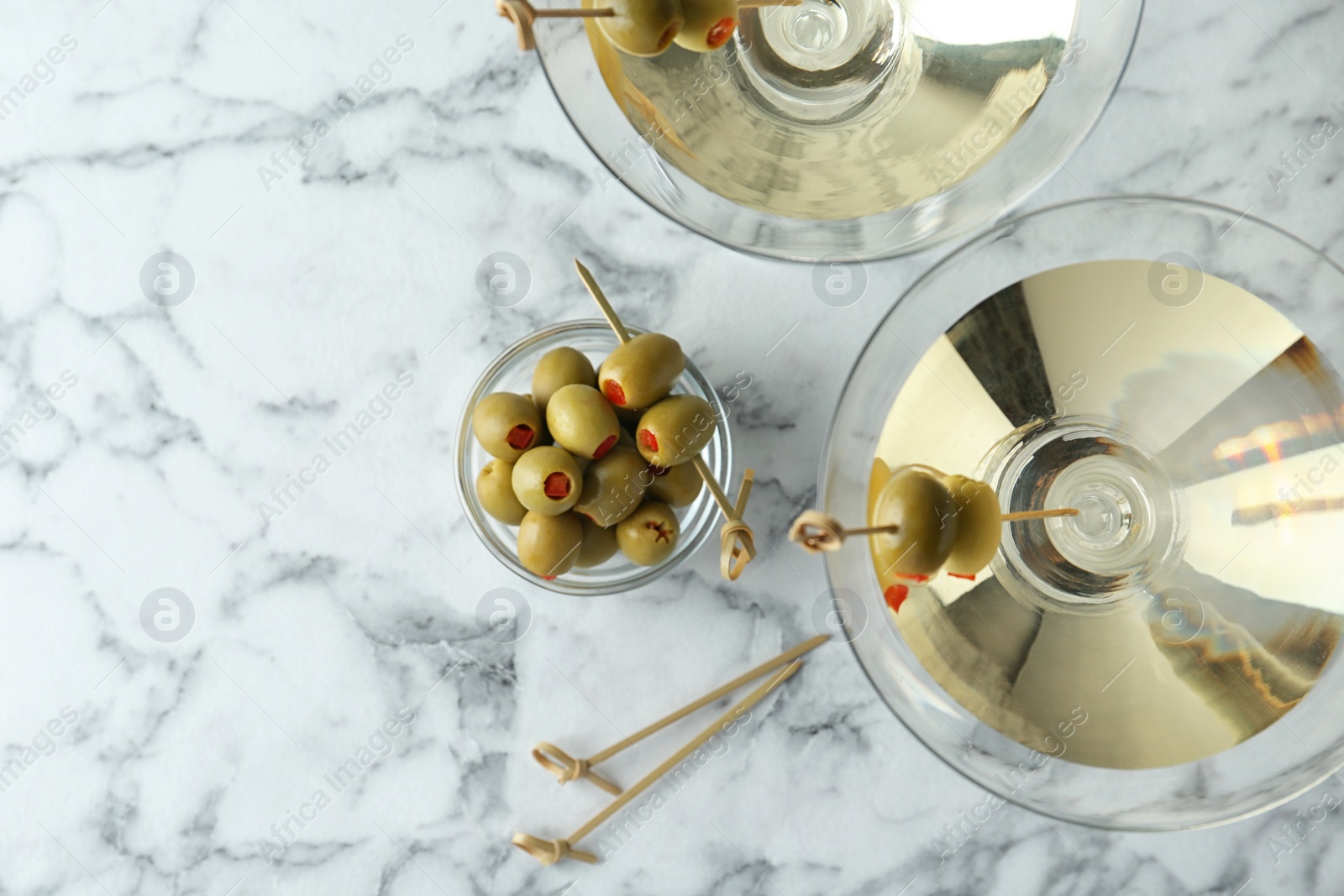 Photo of Flat lay composition with glasses of Classic Dry Martini and olives on white marble table. Space for text