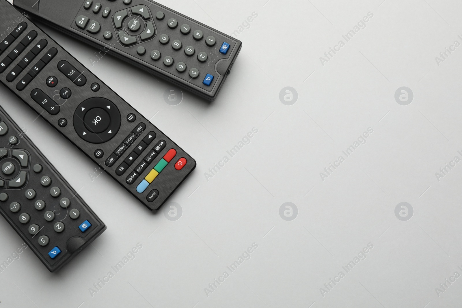 Photo of Remote controls on light grey background, flat lay. Space for text