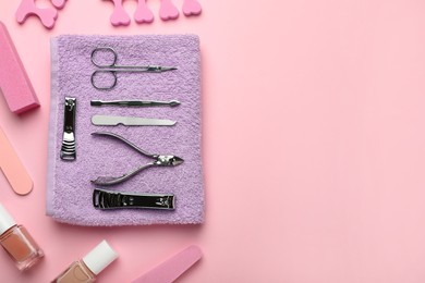 Set of manicure tools and accessories on pink background, flat lay. Space for text