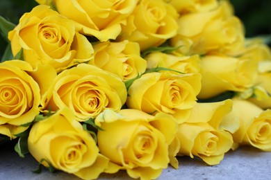 Photo of Beautiful bouquet of yellow roses on light table, closeup