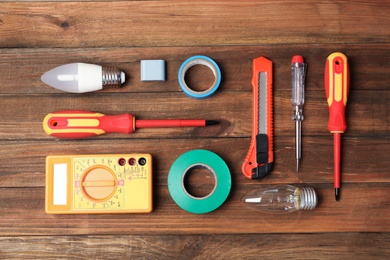 Photo of Flat lay composition with electrician's tools on wooden background