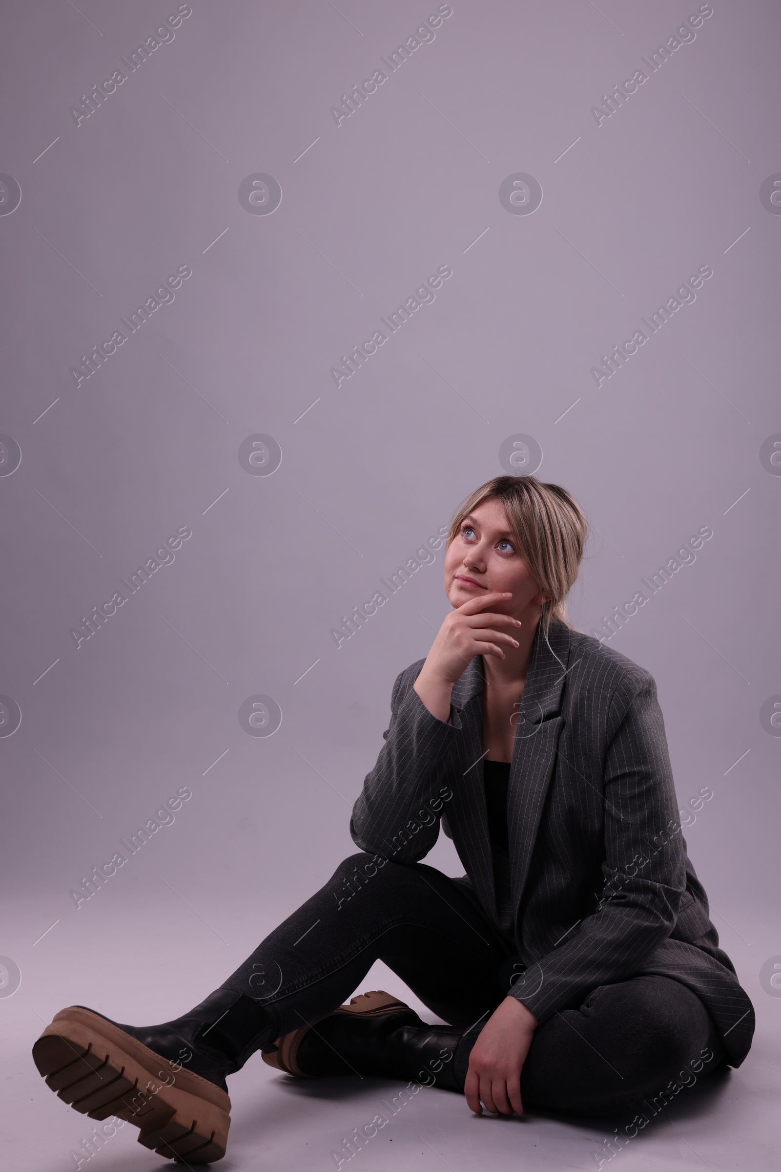 Photo of Beautiful young woman posing on grey background