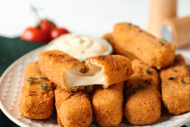 Plate of tasty crispy cheese sticks, closeup