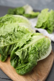 Photo of Fresh green romaine lettuces on grey wooden table, closeup