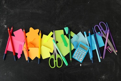 Different stationery on blackboard, flat lay. Back to school