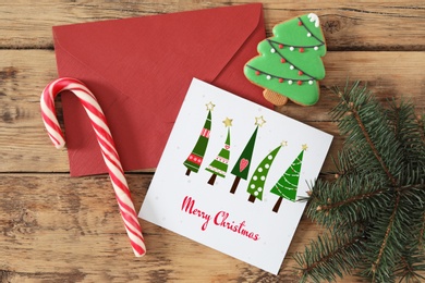 Image of Greeting card with text Merry Christmas on wooden table, flat lay