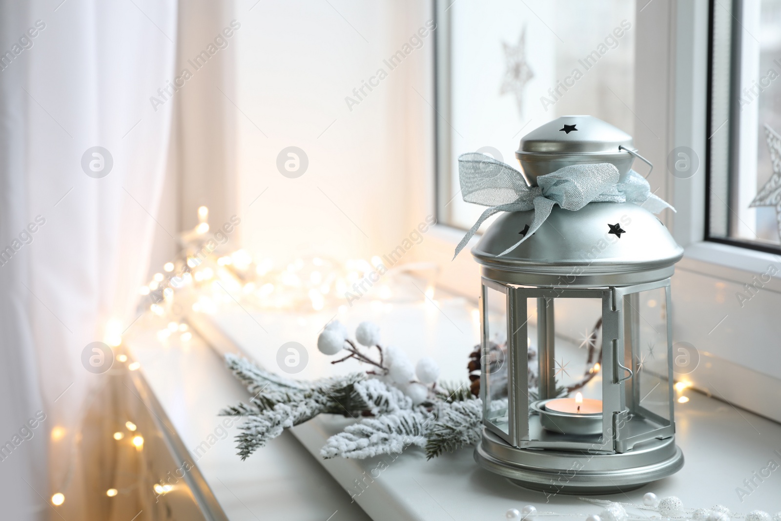 Photo of Beautiful Christmas lantern and other decorations on window sill